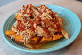 honey siracha pulled chicken over a baked sweet potato
